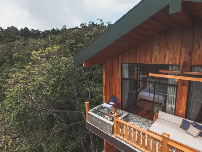 A terrace overlooking Monteverde’s cloud‑forest canopy at Hotel Belmar, where mist, layered greenery, and native flora shape a year‑round bloom experience.